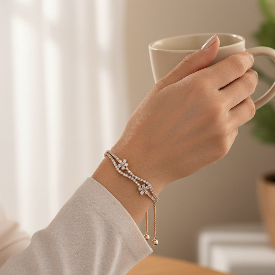 Hand holding a white mug with a bracelet on a blurred indoor background